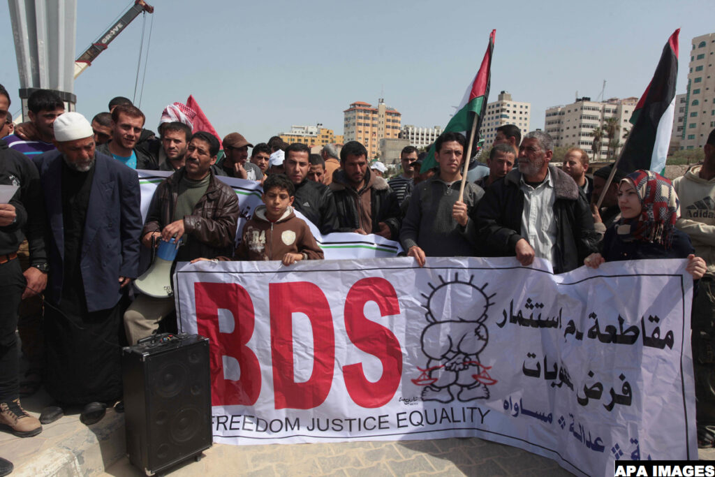 Palestinian fishermen hold banners in a protest to demand the boycott of the Israeli agricultural products, during the 10th annual Israeli Apartheid Week